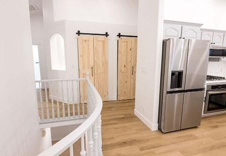 Hall view of pantry with 2 barn doors, stairs and kitchen