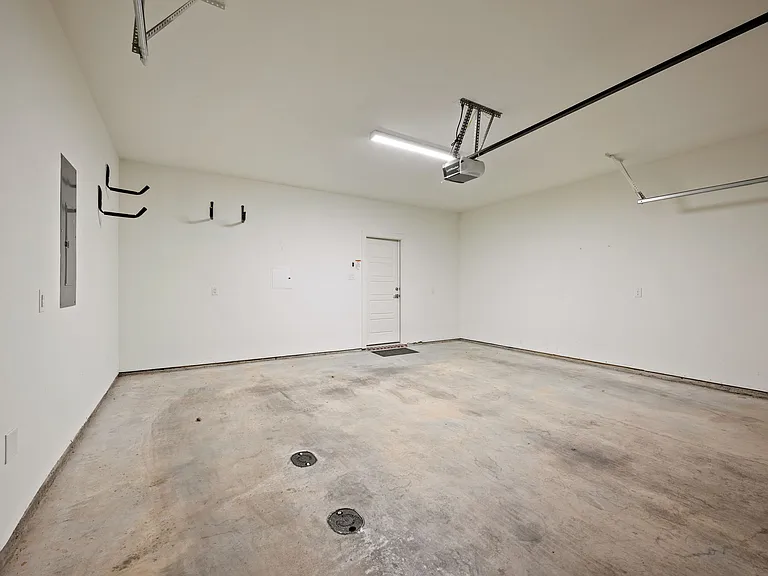 Over-sized, clean two-car garage with built-in bicycle racks. View from garage door to entry into first floor door.