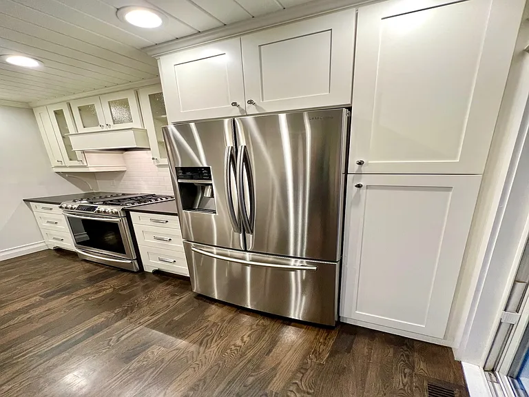 Upscale kitchen w/ stainless steel appliances including a 5-burner gas range, French door refrigerator