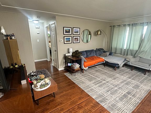 Living room with view to hallway leading to bedrooms and bathroom.