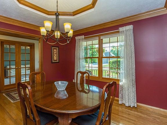 Formal Dining Room off kitchen with glass doors and hardwood floors.