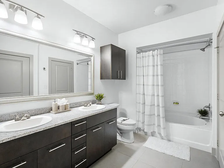 Bright Bathroom with Dual Vanities, Tile Floors, and Shower-Tub Combo