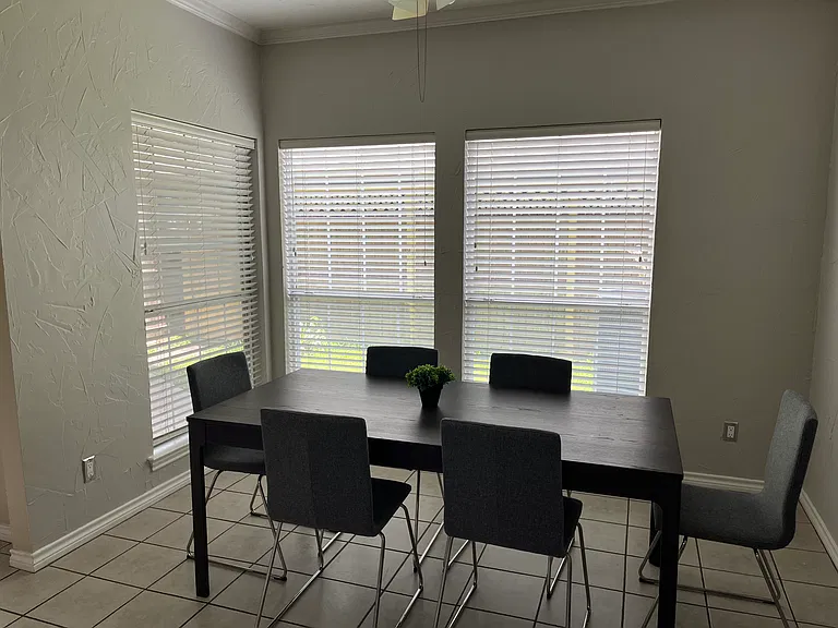 Dinette - furnished with table and six chairs, plus wall decor. Shared space.