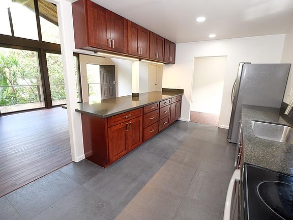 Extra large kitchen island overlooks rainforest