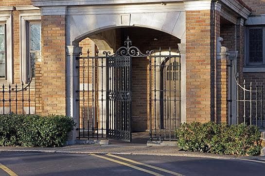 Historical black gate, which provides access to onsite parking from car port located on side of building.