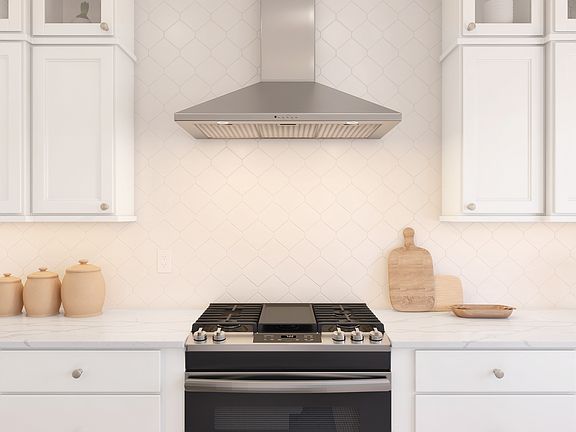 Gas cooktop in kitchen with freestanding hood