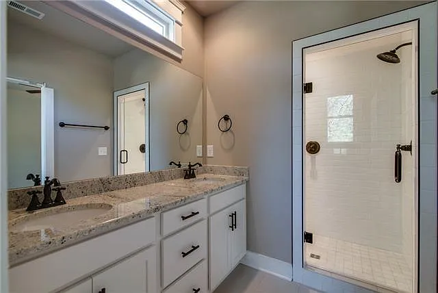 Master bathroom with dual vanity and large walk-in shower with 2 shower heads.