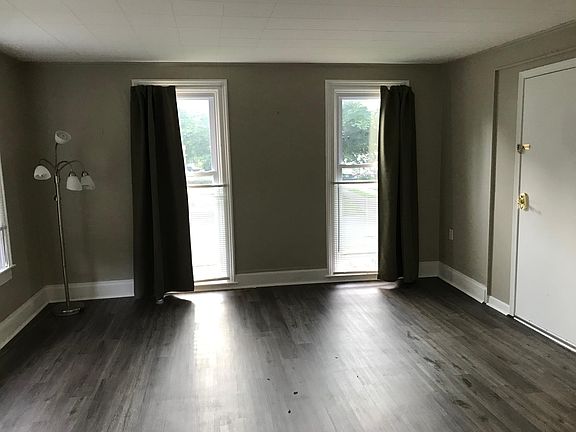Living room with large windows on 2 sides and large storage closet.