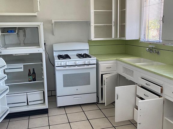 Tiled Kitchen floor, with appliances and view.