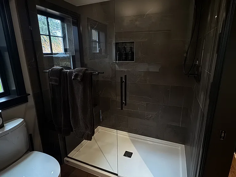Spacious primary bathroom shower with clean, modern design.