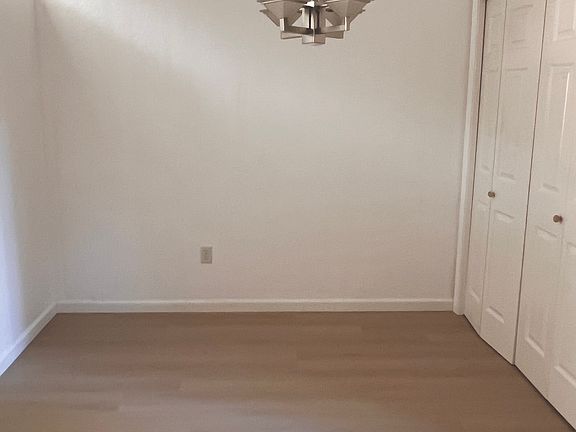Small dining area next to door, adjacent to kitchen, with the light off.
