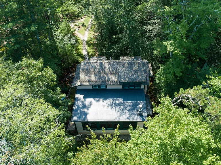 drone shot showing lake side of cottage and walkway to parking area.