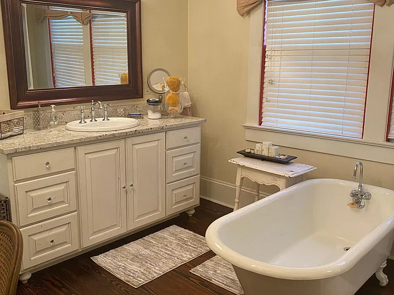 Vintage soaking tub in large bath with fireplace