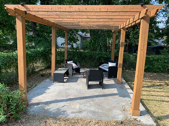 pergola in fenced back yard; outdoor furniture will remain with the property