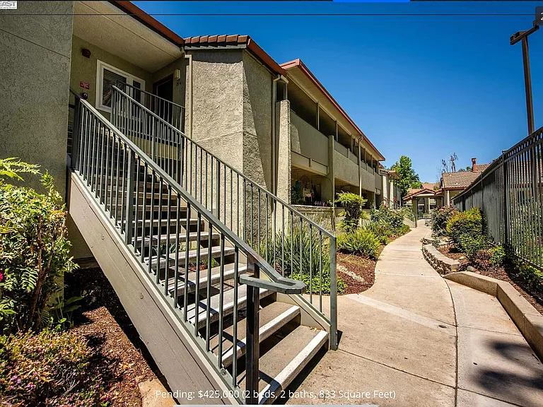 Pool is to the right. Unit is up the stairs on the right. Patio is facing the pool and open space. You don't feel like you are in a complex because entrance to the complex is close to the unit.