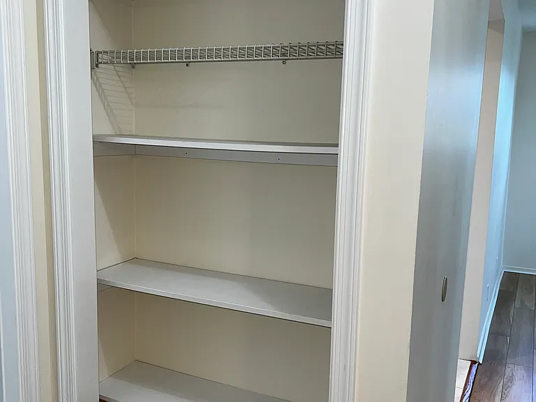 Ample storage just outside of bath along with a hall closet and smoke detector .