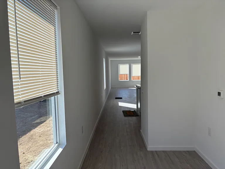 Front door hall way leads to kitchen and living room. Home is well lit and easy push up and pull blinds installed for all windows.