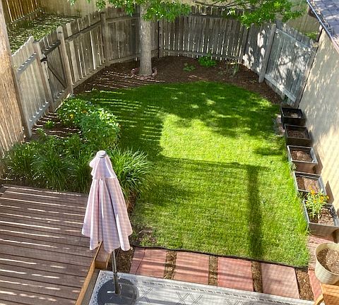 VIEW FROM STREET (UPPER LEVEL) BEDROOM LOOKING DOWN AT DECK AND PRIVATE FENCED YARD