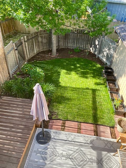 VIEW FROM STREET (UPPER LEVEL) BEDROOM LOOKING DOWN AT DECK AND PRIVATE FENCED YARD