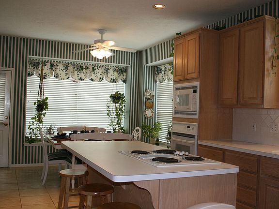 This kitchen has built-in appliances, with an island stove and bar.