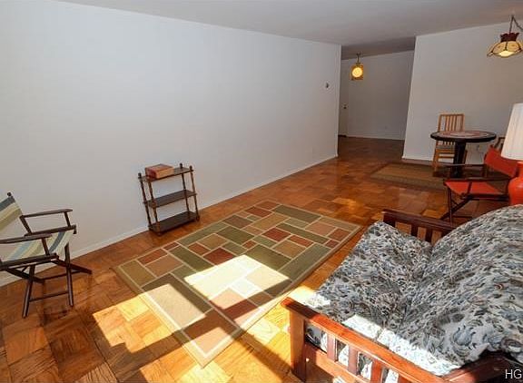 Large sunny living room with dining area and refinished parquet floors.