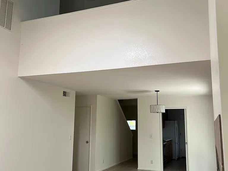 Main room looking toward lofted bedroom, kitchen and entry way