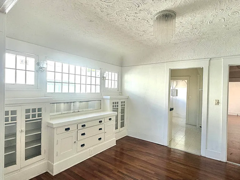 Dining room area with original cabinets and cove ceilings