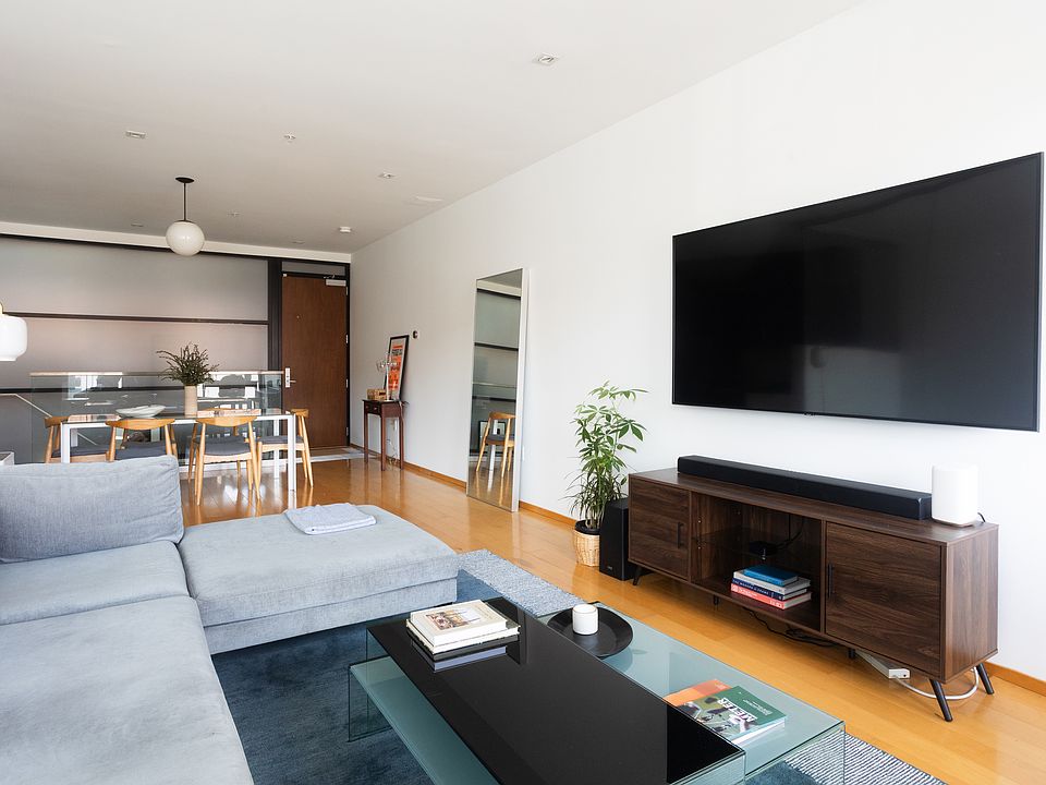 Upon entering, main living space with wall-mounted TV and soundbar.