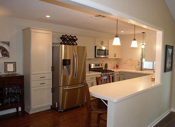 The kitchen opens to the living area. Updated cabinetry, lighting fixtures, corian counters, and appliances.