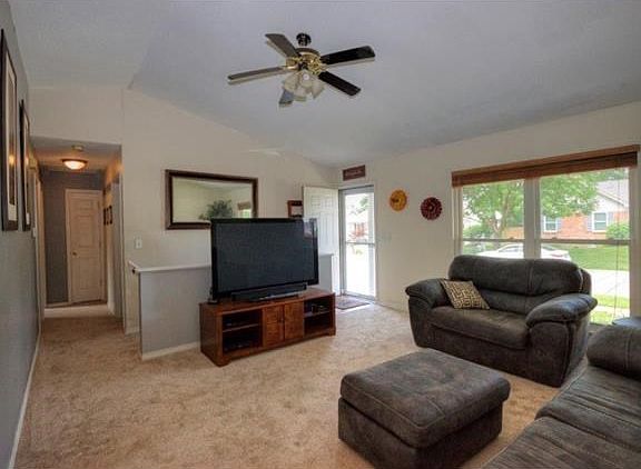 Living room with NEW carpet and large picture window!  Ceiling light & fan to keep you cool!