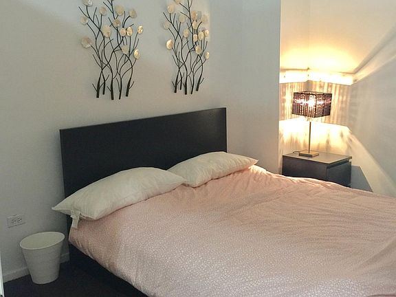 1st bedroom off the foyer with a queen bed.