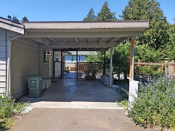 Large carport that leads to side patio door and gate into huge patio area