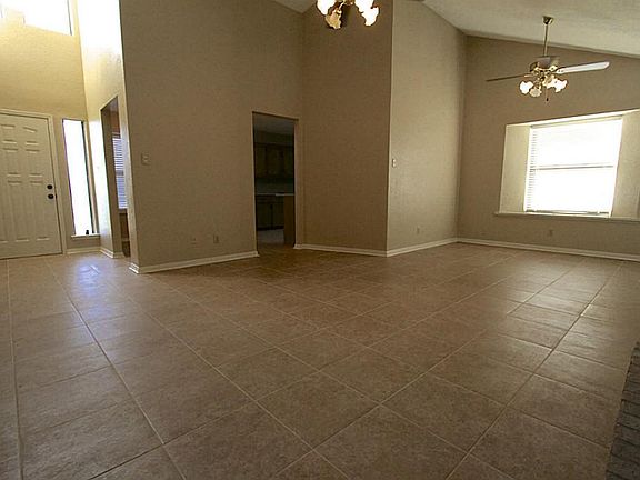 View of combined living/dining areas.  Vaulted, tall windows above entry allows natural light and open concept.