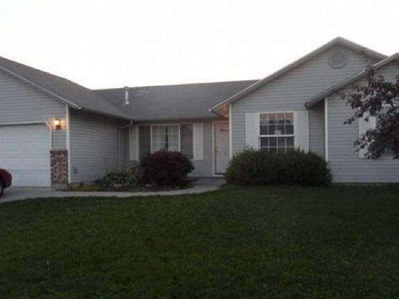 Front of house partial view. There is a 3 car garage.