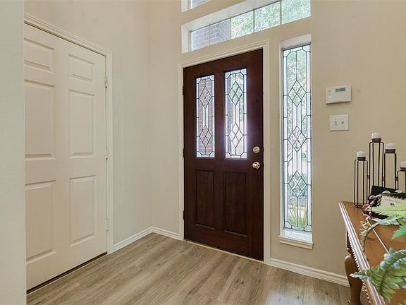 Leaded Glass Front Door features a Side Panel and Tall Window that allows an abundance of Natural Light into the Two Story Foyer!