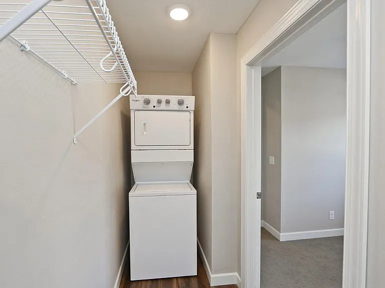Full sized stacked washer and dryer in walk in bedroom closet