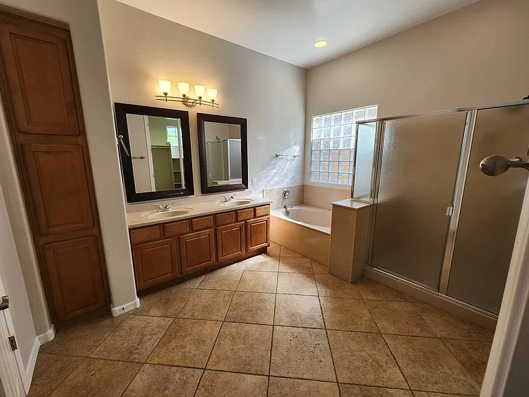 Primary bathroom with lots of light and linen cabinets
