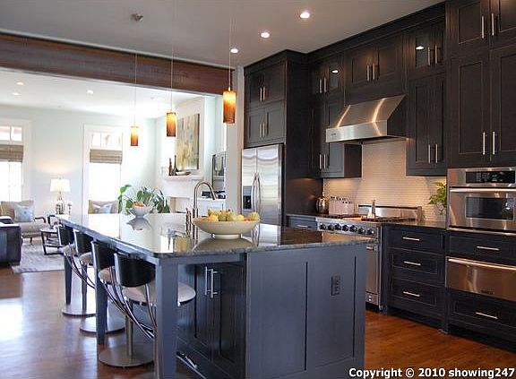 Gorgeous kitchen with huge slab Lemurian Blue granite island, Black Magic cabinetry to the ceiling, 