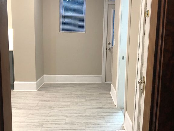Looking from the front hall into the kitchen, this photo shows the door to the basement on the immediate right and then the half bath door on the second right. Straight ahead is the back door, which opens into the kitchen.