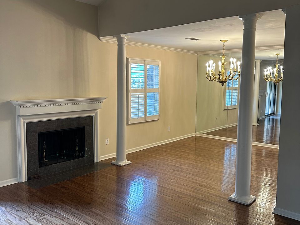 Living room with vaulted ceiling and dining room with mirrored wall