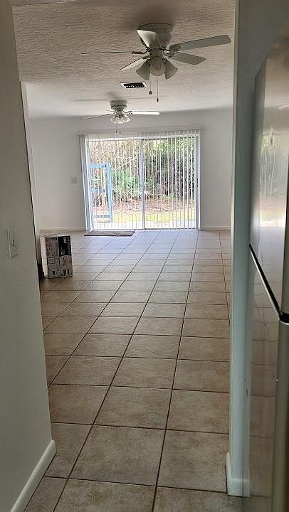 Kitchen looking through dining and living room to back yard