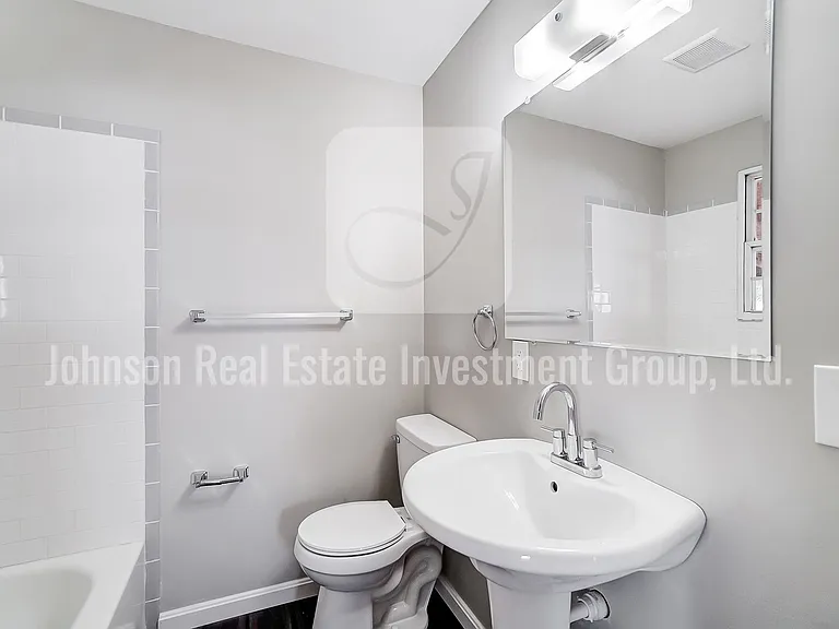 Fully remodeled first-floor bathroom with a pedestal sink and subway tile tub surround.