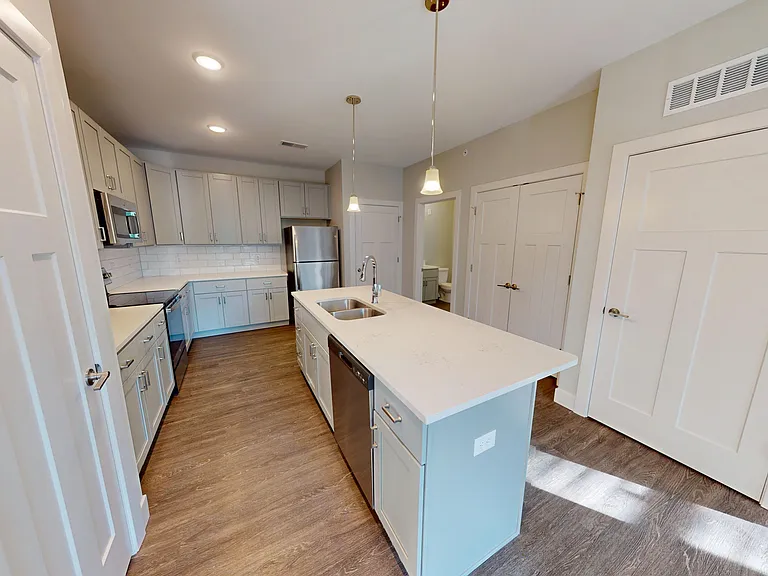 The Elm kitchen features a kitchen island with double sinks, a dishwasher, and breakfast bar. The Elm kitchen features a kitchen island with double sinks, a dishwasher, and breakfast bar.