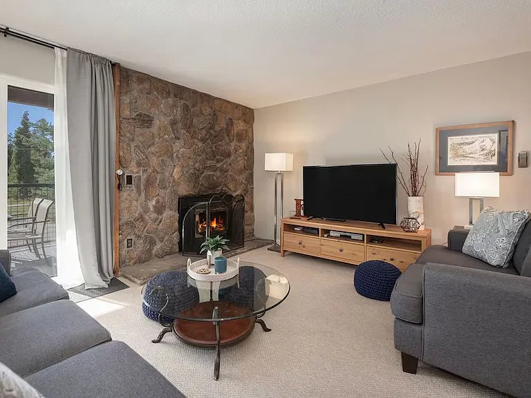 Living Room with Gas Fireplace and Deck off of Sliding Glass doors.