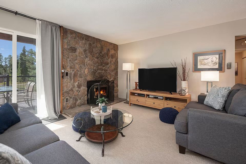 Living Room with Gas Fireplace and Deck off of Sliding Glass doors.