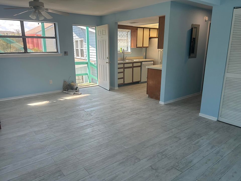 Entry into the living room with kitchen on left, hallway to second bedroom and bath.