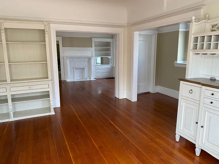 front room with bay windows, opens to additional dining/living room (separates by large original pocket door)