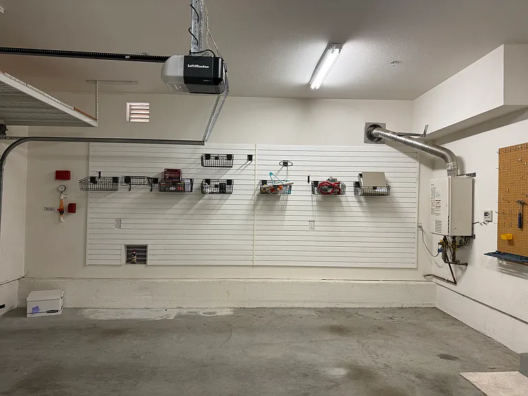 Attached 2-car garage features organized shelving.