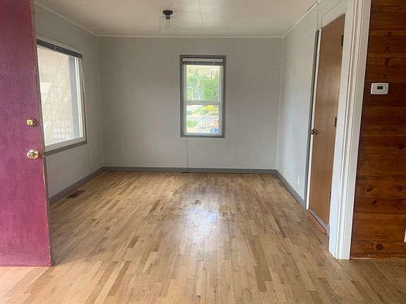 Front door opens to Living room with windows on three sides.