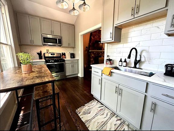 Updated kitchen with large sink and stainless steel appliances.